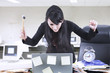 Angry businesswoman with hammer and laptop