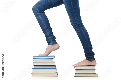 Photo: Student sitting on stack of books Student sitting on stack of books