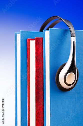 Photo: Concept of audio books with earphones on white Concept of audio books with earphones on white