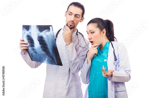 Photo: Two doctors looking at x-ray image on white Two doctors looking at x-ray image on white