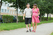 a happy young pregnant woman with her husband walking in a park