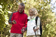 A mature couple walking, looking at a smartphone