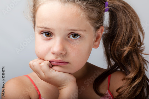Photo: Sad girl on grey background Sad girl on grey background