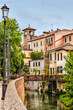 View of old houses and their reflection in a water canal Padua