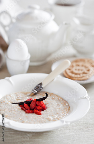 Photo: Oat bran porridge with vanilla and goji berries. Selective focus Oat bran porridge with vanilla and goji berries. Selective focus