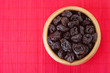 Photo: Dried prunes in wooden bowl Dried prunes in wooden bowl