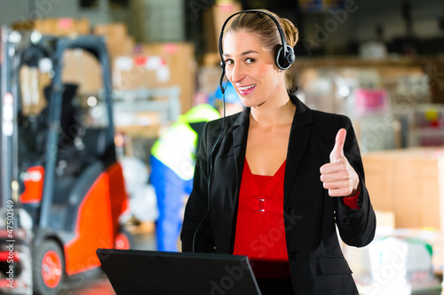 Photo: Frau mit Headset in Lagerhalle einer Spedition Frau mit Headset in Lagerhalle einer Spedition