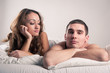 Closeup portrait of a tired young couple lying in bed.