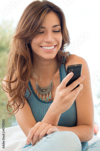 Photo: Woman Smiling And Holding Mobile Phone Woman Smiling And Holding Mobile Phone