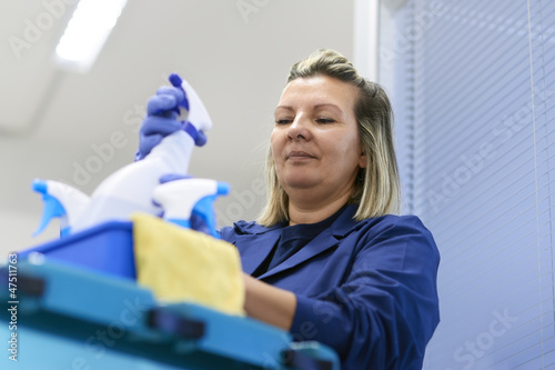 Photo: Woman working as professional cleaner in office Woman working as professional cleaner in office