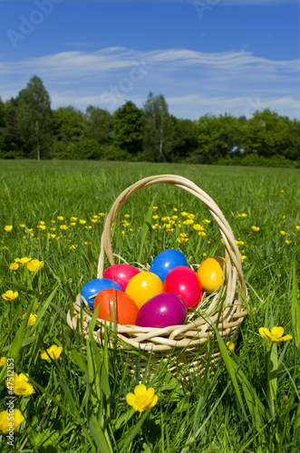Photo: Osterkorb mit bunten Ostereiern auf einer grünen Blumenwiese Osterkorb mit bunten Ostereiern auf einer grünen Blumenwiese