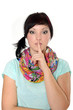 Junge Frau mit Finger auf den Lippen