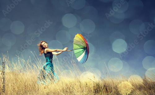 Photo: Redhead girl with umbrella at outdoor. Redhead girl with umbrella at outdoor.