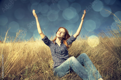 Photo: Portrait of happy red-haired girl on autumn grass. Portrait of happy red-haired girl on autumn grass.