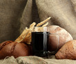tankard of kvass and rye breads with ears, on burlap background