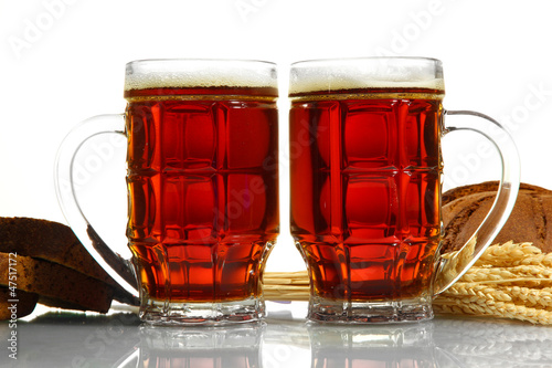 Photo: tankards of kvass and rye breads with ears, isolated on white tankards of kvass and rye breads with ears, isolated on white