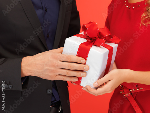 Photo: man and woman's hands with gift box man and woman's hands with gift box