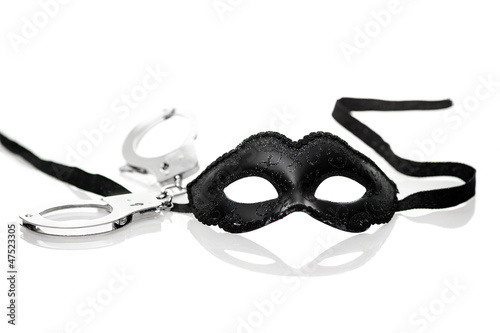 Photo: Black mask and handcuffs on white background Black mask and handcuffs on white background