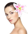 Beauty face of young woman with flower. Beauty treatment concept