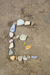 The Letter E with Stones on Sand