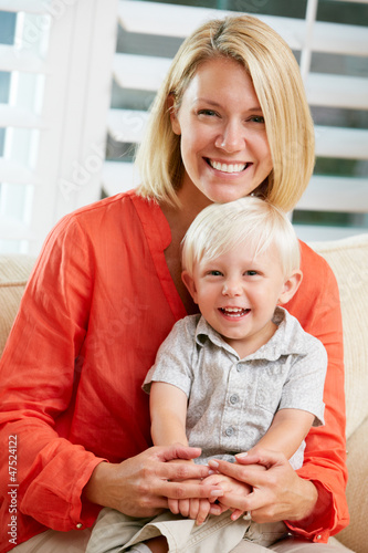 Photo: Portrait Of Mother And Son Sitting On Sofa At Home Portrait Of Mother And Son Sitting On Sofa At Home