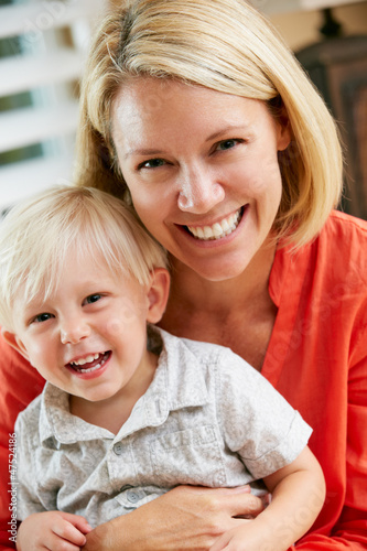 Photo: Portrait Of Mother And Son Sitting On Sofa At Home Portrait Of Mother And Son Sitting On Sofa At Home