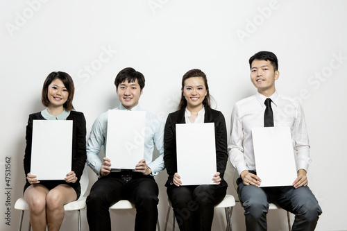 Photo: Chinese Business team hold up blank cards. Chinese Business team hold up blank cards.
