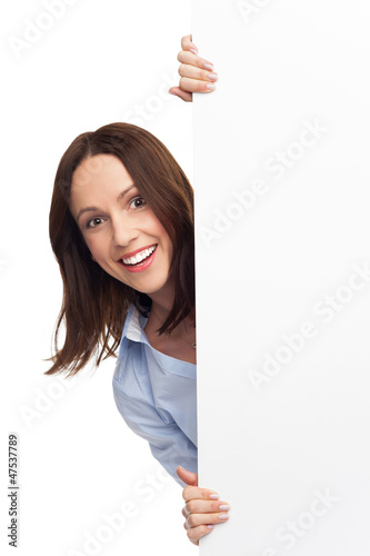 Photo: Woman peeping over blank poster Woman peeping over blank poster