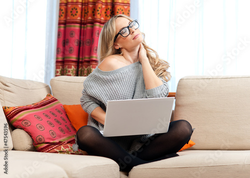Photo: attractive woman with laptop having neck pain attractive woman with laptop having neck pain