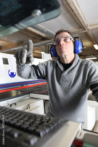 Photo: Man using computer controlled factory machine Man using computer controlled factory machine