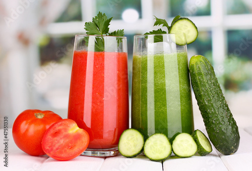 Photo: Fresh vegetable juices on wooden table, on window background Fresh vegetable juices on wooden table, on window background