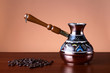 Turkish coffee pot and a handful of roasted coffee beans