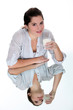 Woman drinking a glass of milk on a mirrored table