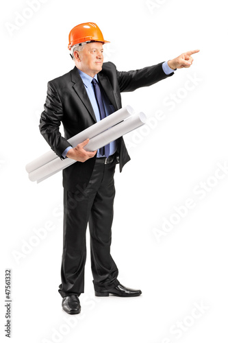 Photo: Mature architect holding a blueprint and pointing Mature architect holding a blueprint and pointing
