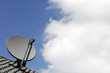 Satellite dish on roof against blue sky and cloud 