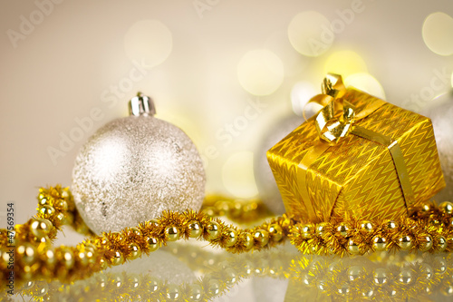 Photo: Christmas gift and baubles over shiny lights background Christmas gift and baubles over shiny lights background