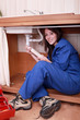 Young woman fixing water pipes