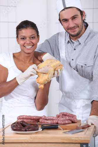 Photo: two butchers cutting fresh meat two butchers cutting fresh meat