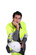 Studio portrait of a man in fluorescent work clothes and helmet