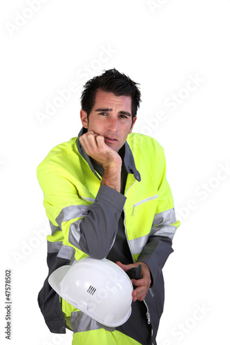 Photo: Studio portrait of a man in fluorescent work clothes and helmet Studio portrait of a man in fluorescent work clothes and helmet