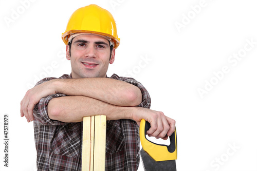 Photo: Mason holding handsaw and plank of wood Mason holding handsaw and plank of wood