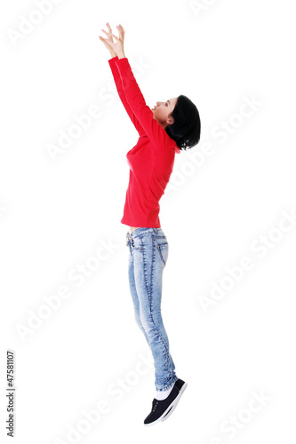 Photo: Teen girl jumping in air trying to catch something. Teen girl jumping in air trying to catch something.