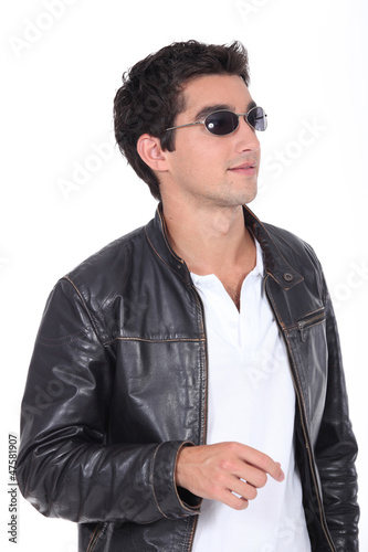 Photo: young man wearing leather jacket and sunglasses young man wearing leather jacket and sunglasses