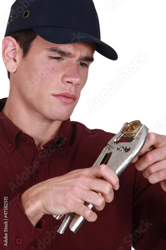 Photo: Plumber holding wrench and pipe Plumber holding wrench and pipe