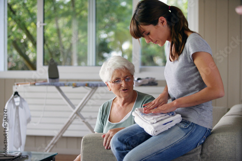 Photo: young woman helping senior lady with the housework young woman helping senior lady with the housework