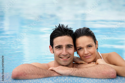 Photo: Couple stood together in swimming pool Couple stood together in swimming pool