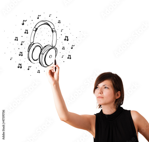 Photo: Young girl drawing headphone and musical notes Young girl drawing headphone and musical notes