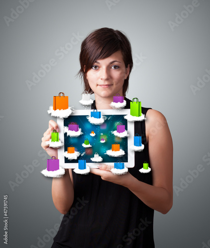 Photo: woman holding modern tablet with colorful shopping bags on cloud woman holding modern tablet with colorful shopping bags on cloud