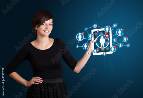 Photo: young woman holding tablet with social network icons young woman holding tablet with social network icons