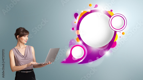 Photo: attractive woman holding a laptop and presenting abstract speech attractive woman holding a laptop and presenting abstract speech